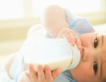 Baby die drinkt uit fles melk