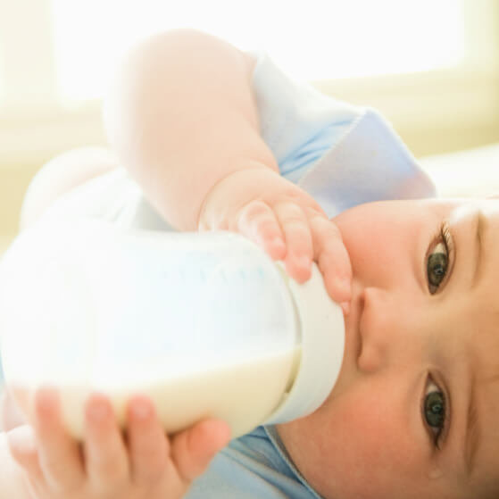 Baby die drinkt uit fles melk