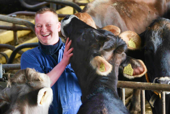 Boer knuffelt met een van zijn koeien